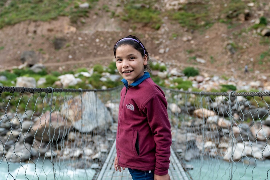 Devi stands on a bridge.