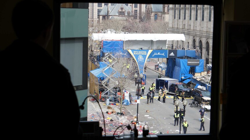 Emergency personnel remain at the site of the Boston marathon blast, as seen from a nearby office window.