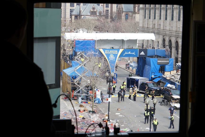 Emergency personnel remain at the site of the Boston marathon blast, as seen from a nearby office window.