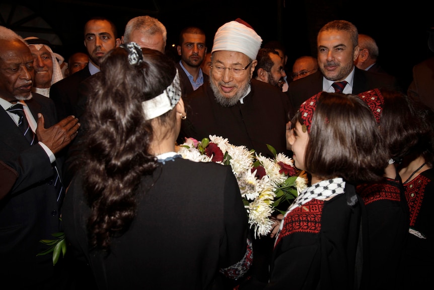 A Muslim cleric receives flower from Palestianian girls.