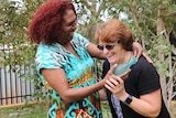 A photo of two women laughing as they pose for a photo in Broome