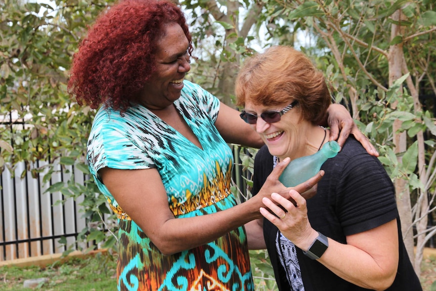 A photo of two women laughing as they pose for a photo in Broome