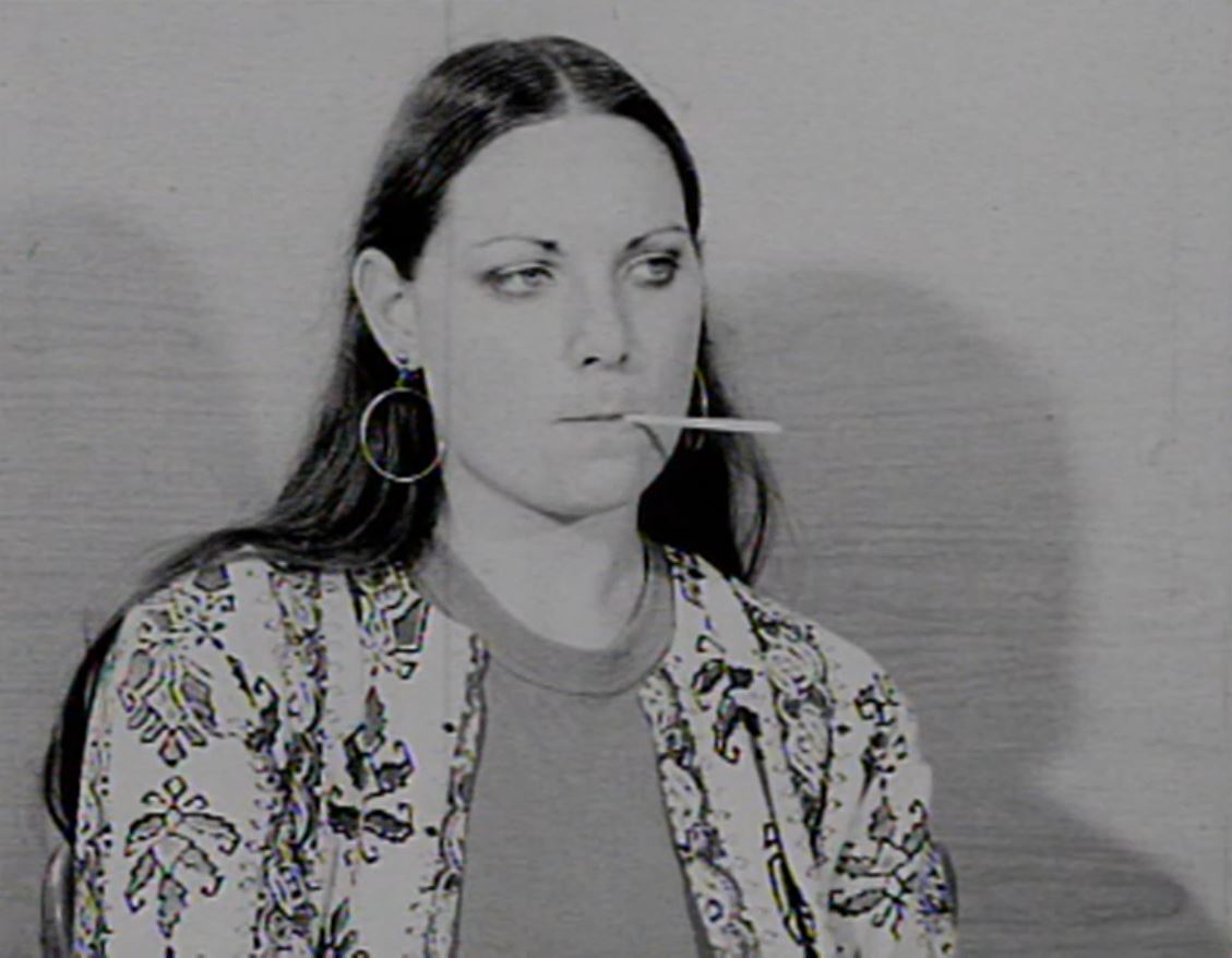 black and white image of a woman with a thermometer in her mouth