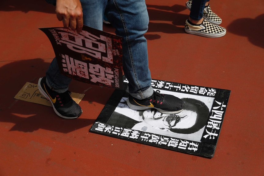 A protester steps on a poster depicting former Chinese Premier Li Peng reading "June 4th Butcher"