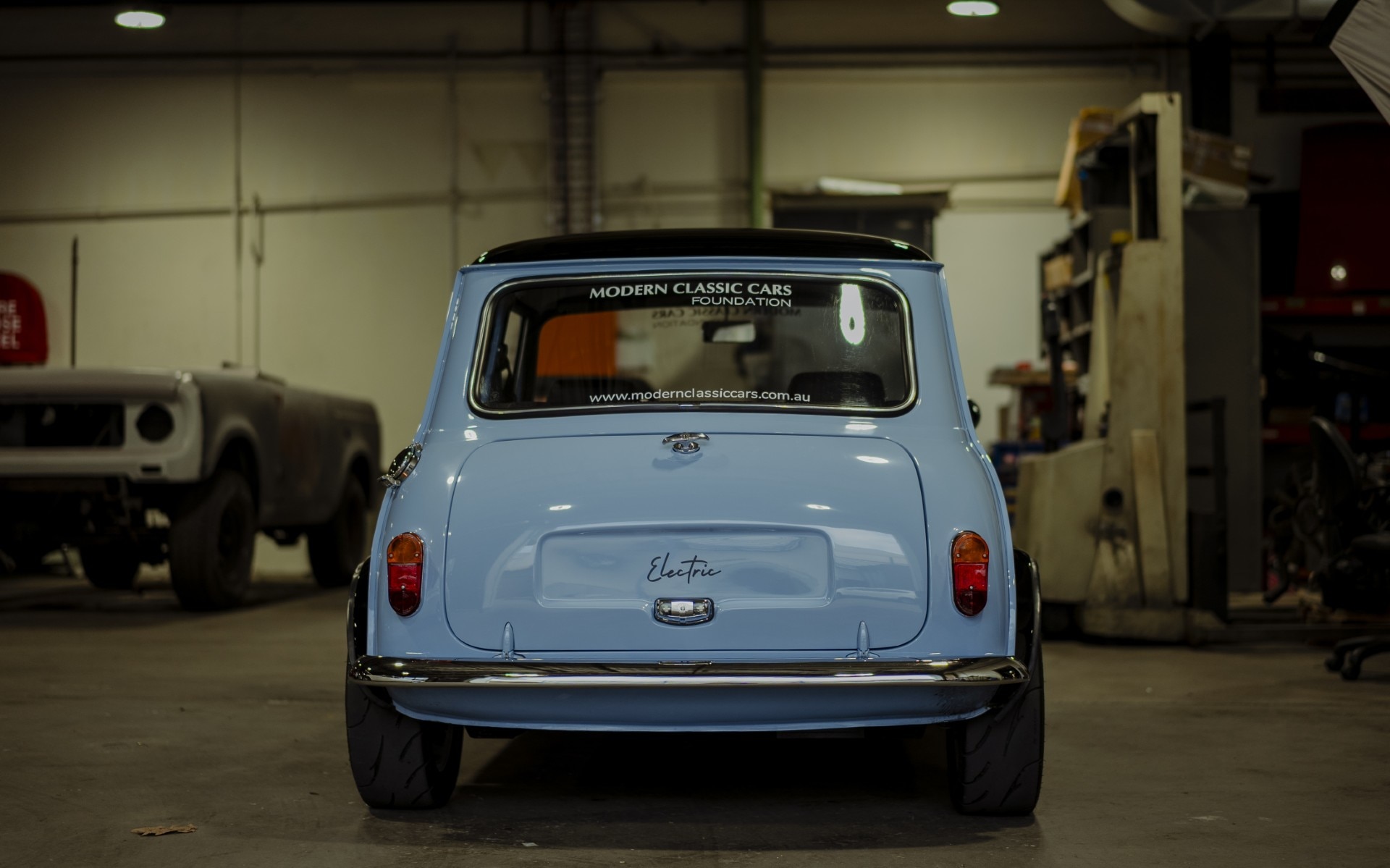 Back of small blue car with "electric" written on boot