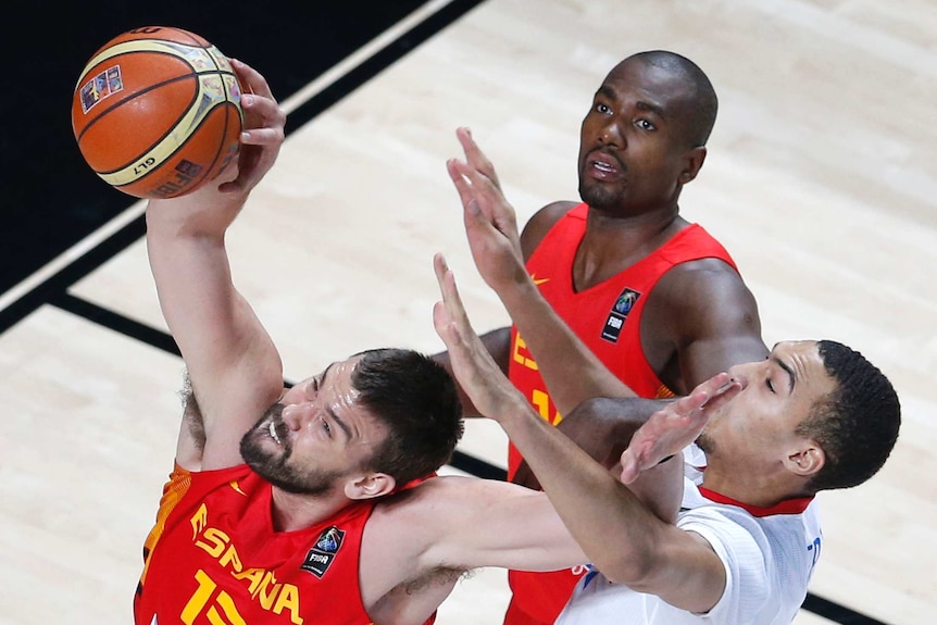 Spanish basketballer challenges for a rebound in their basketball match against France.