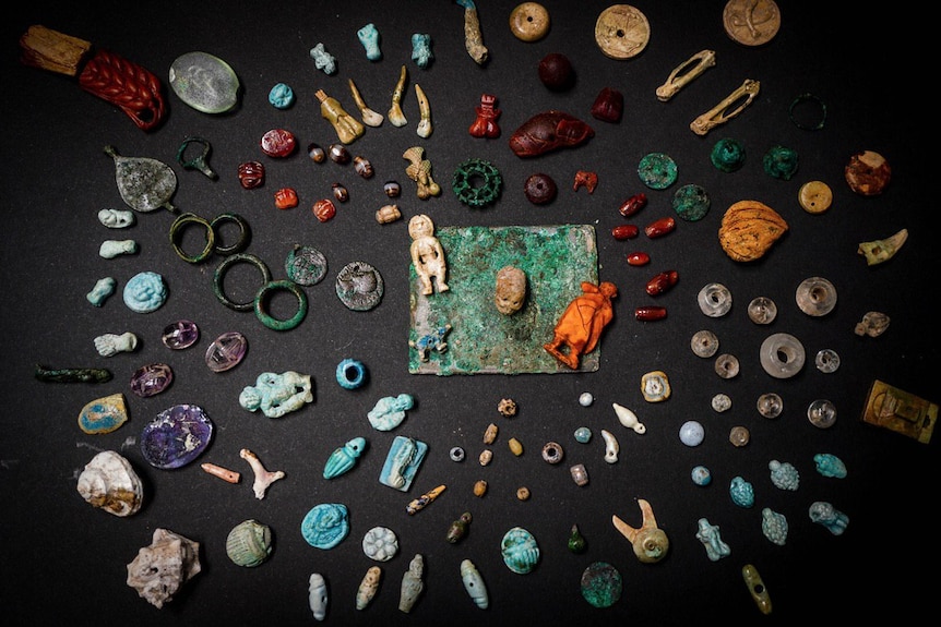 Ancient artefacts excavated from Pompeii are spread across a carpet.