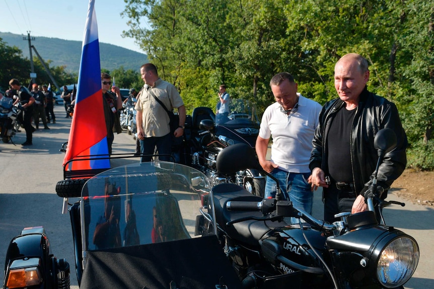 Mr Putin stands next too a Russia made "Ural" motorbike.