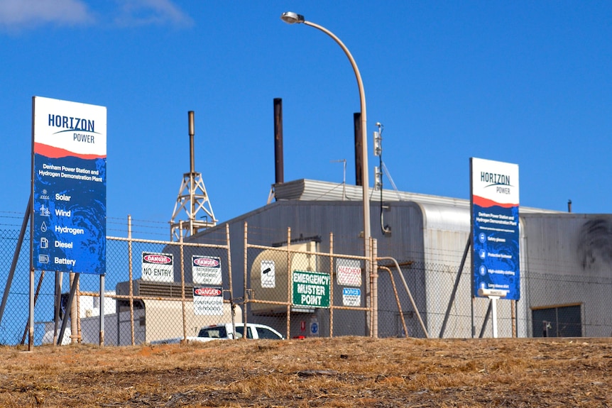 Usine d'hydrogène avec des signes qui disent horizon power, solaire, vent, hydrogène, diesel, batterie 