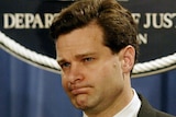 A headshot of Christopher Wray during a press conference.