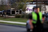 Emergency vehicles sit in front of a FedEx distribution centre where a package exploded.