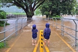 Two boys stand near a flooded park