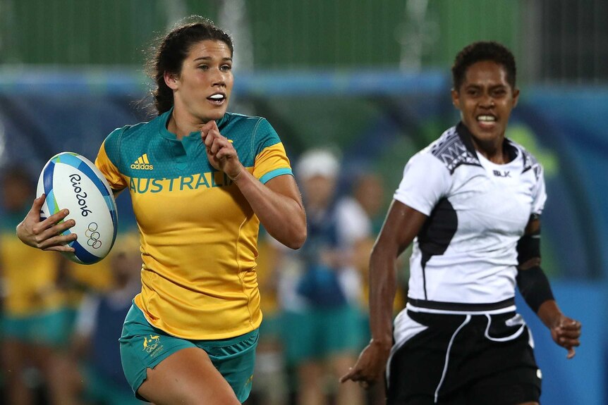 Charlotte Caslick runs past Fijian rival in rugby sevens in Rio