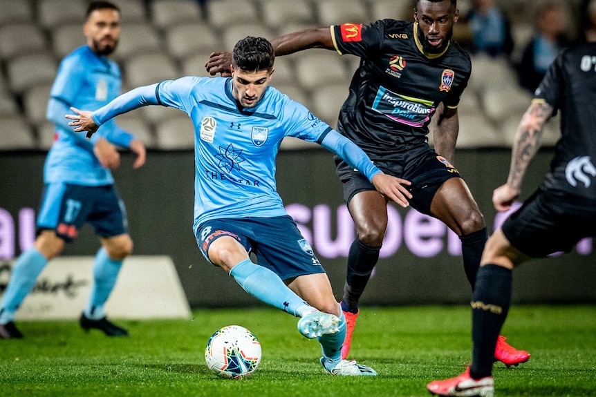 Paolo Retre looks down at a football as he plays it with the outside of his foot