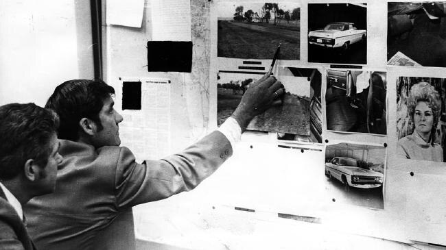 Detectives looking of photos of the crime scene of the 1975 murder of Perth brothel madam Shirley .