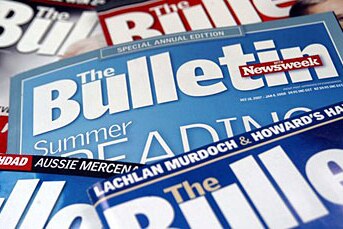 Numerous issues of The Bulletin magazine scattered on a table.