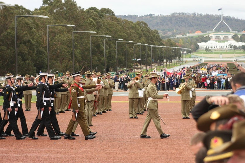 Soldiers march in front of a crowd at the Anzac Day Parade in Canberra.