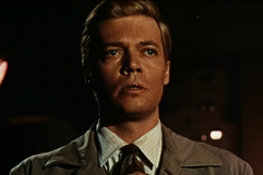 A still showing a character in a trench coat.