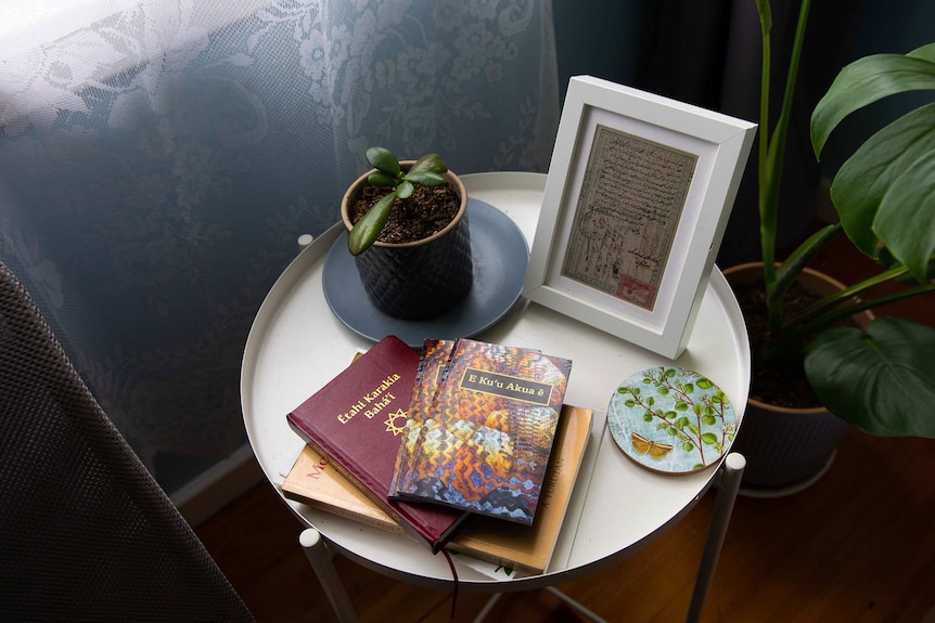 Baha'i books and pot plant on a coffee table.