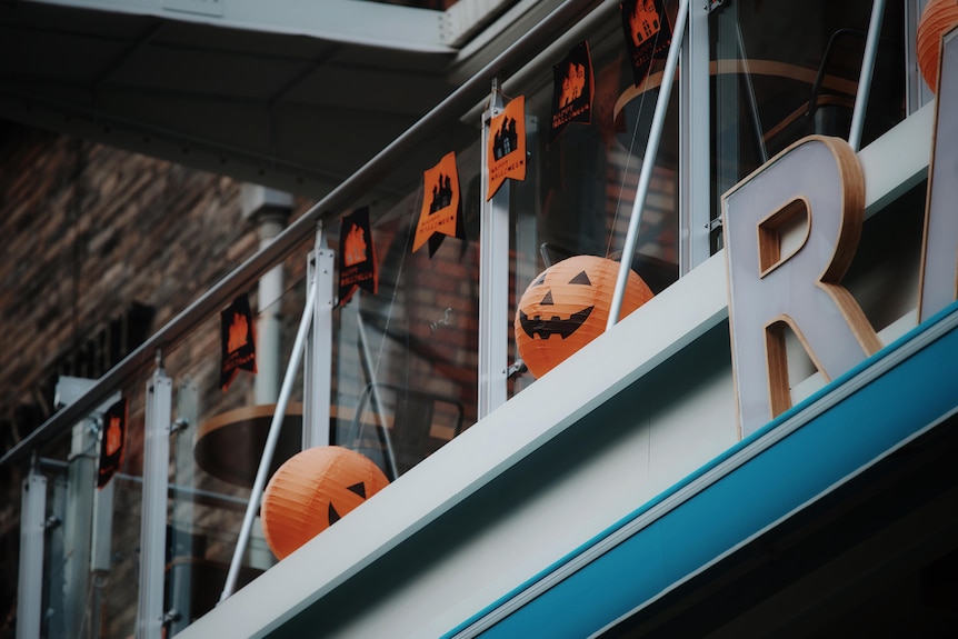 Pumpkin lanterns and Halloween-themed bunting are hung across a balcony 