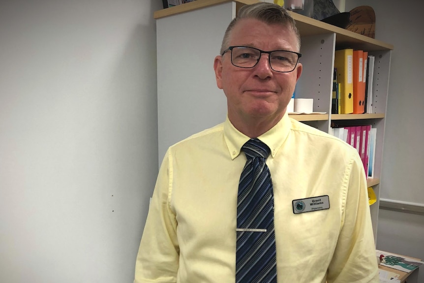 A man stands in front of office stationary.