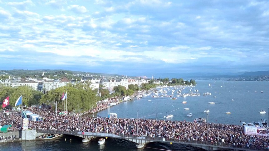 crowds of people gather over a bridge in Switzerland