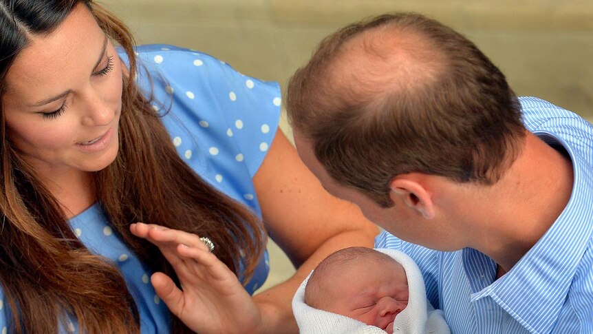 Prince William stares into the eyes of his baby son as wife Catherine looks on outside the Lindo Wing of St Mary's Hospital.