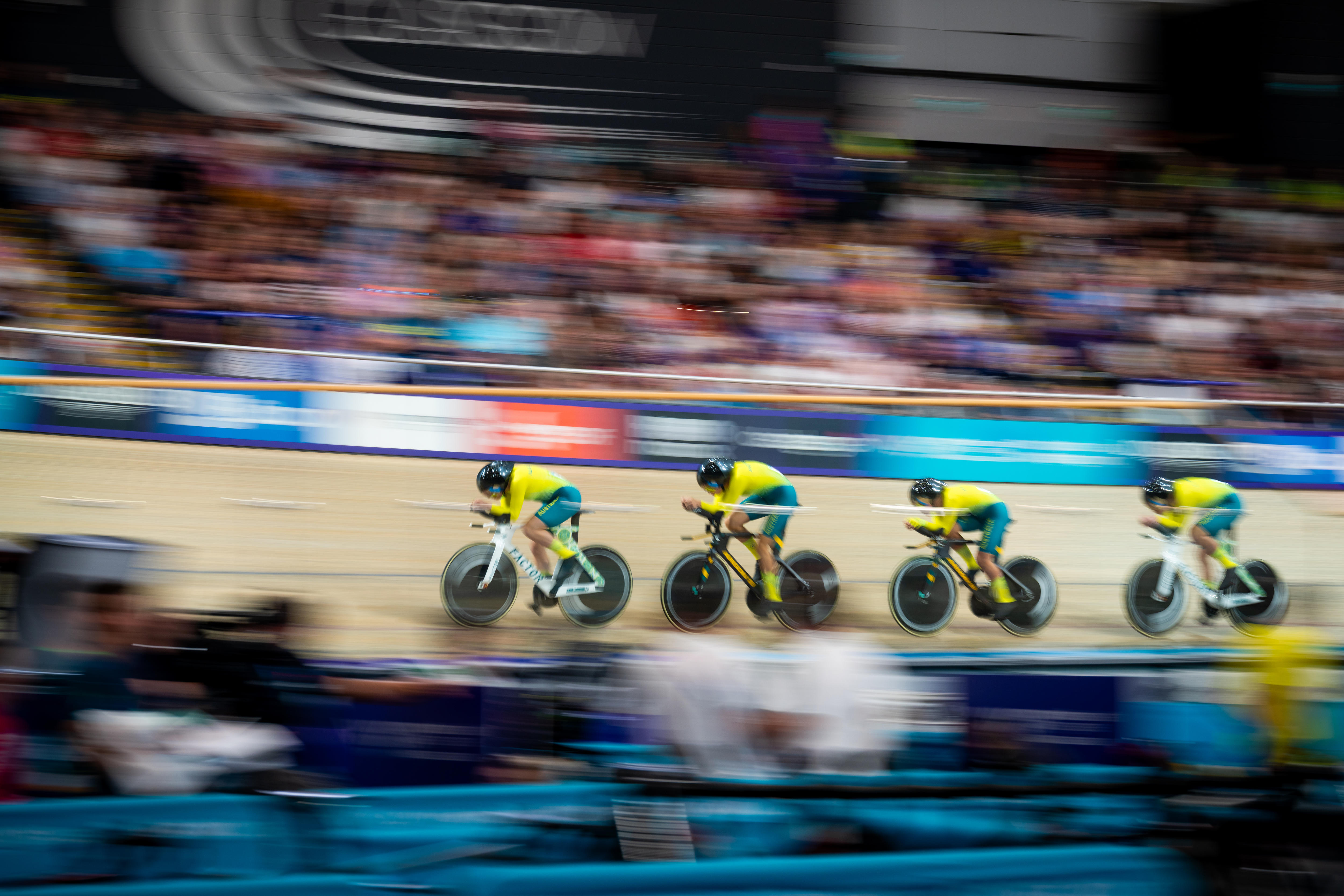 Cyclists speed around a velodrome