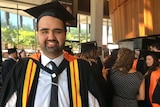 Joshua Paulson, at the University of Newcastle's graduation ceremony, standing inside Port Macquarie's Glasshouse.