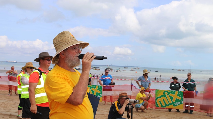 Des Gelert speaks into a microphone at Mindil Beach for Darwin's Beer Can Regatta.