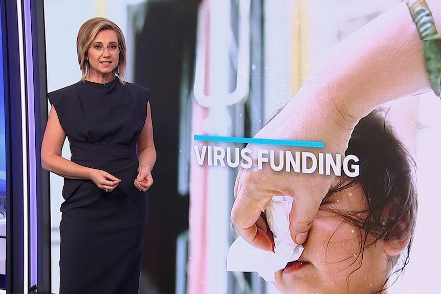 A newsreader speaks next to a graphic of a child having their nose blown with the words 'Virus Funding'.