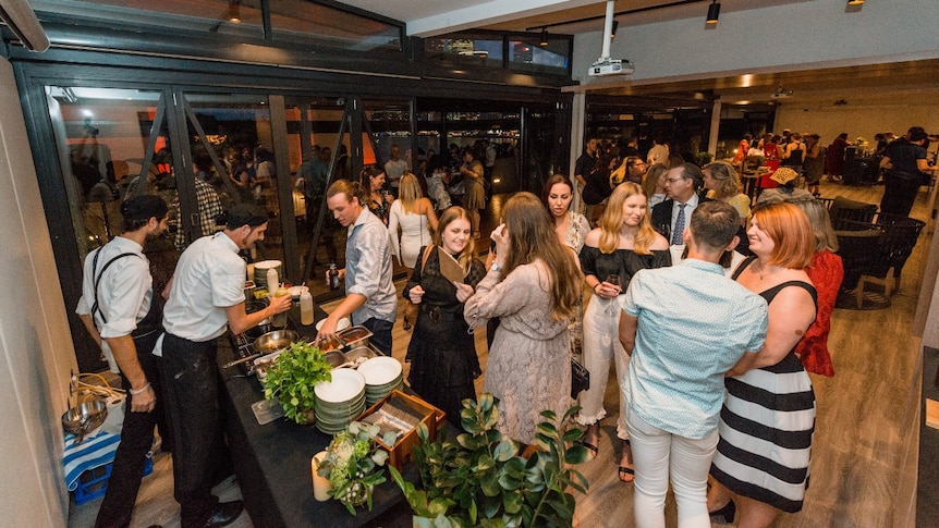 Staff at a law firm gather inside a venue for their Christmas party.