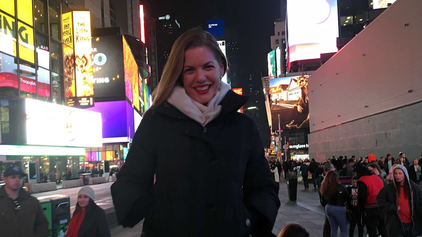 Hannah Durack in New York City in Times Square smiling at the camera.