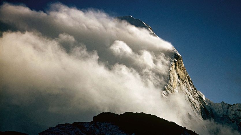 Clouds rush over a peak in the Himalayas