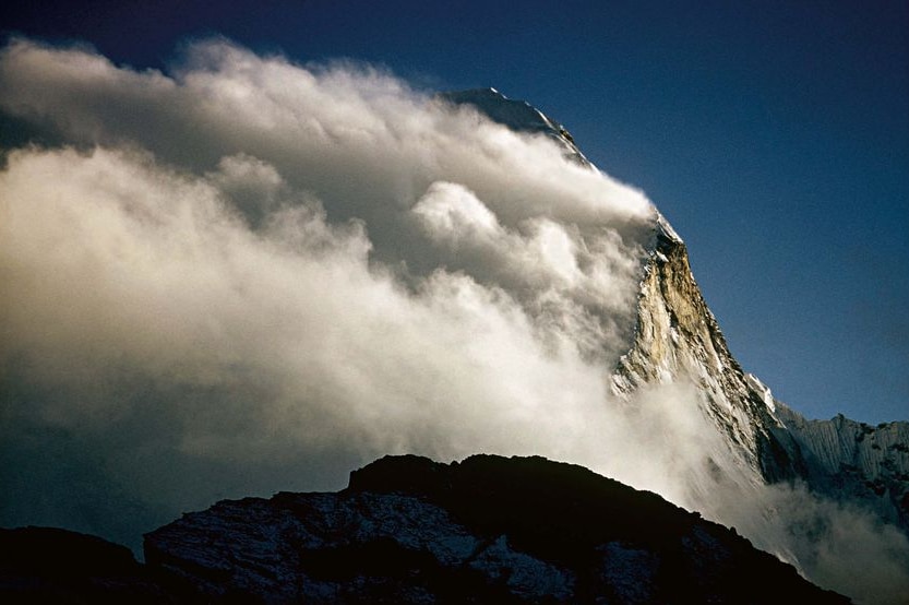 Clouds rush over a peak in the Himalayas