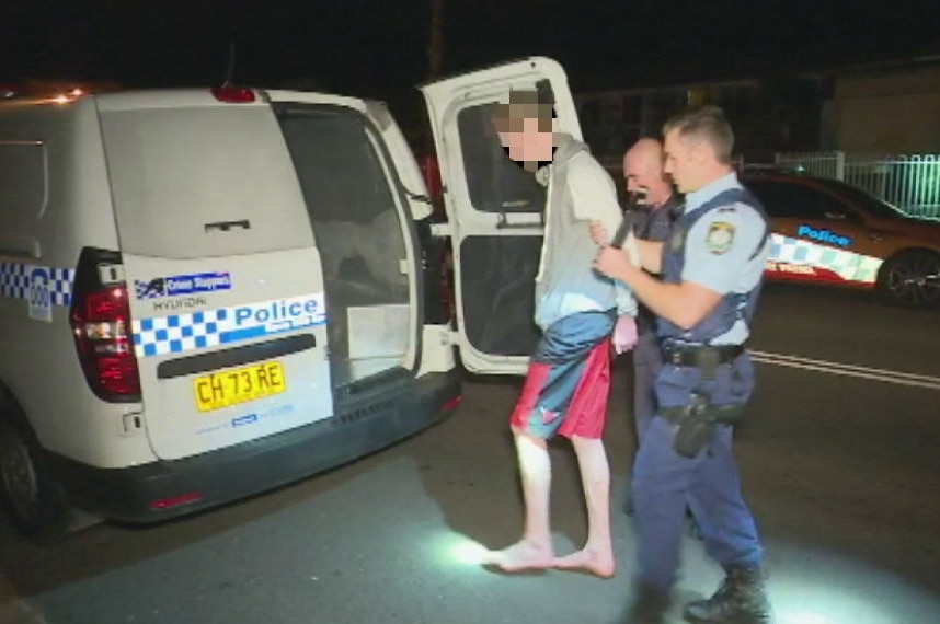 A man is led away by police.