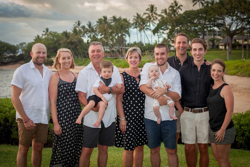 Three generations of the Winn family pose for a family portrait on a tropical beach