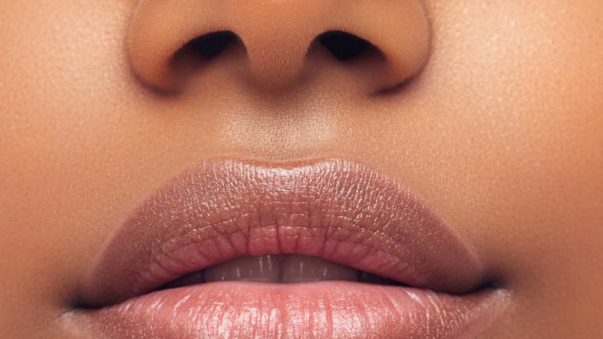 A close up of a woman's nose and mouth with lipstick