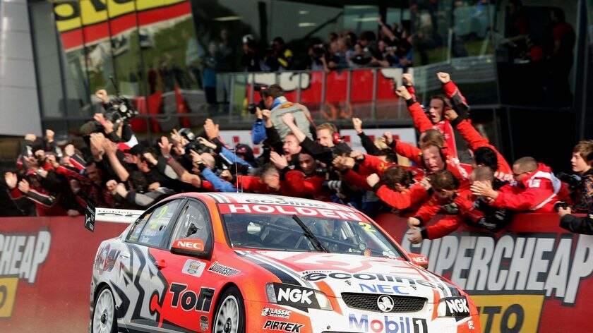 Garth Tander is congratulated by his team as he crosses the finish line
