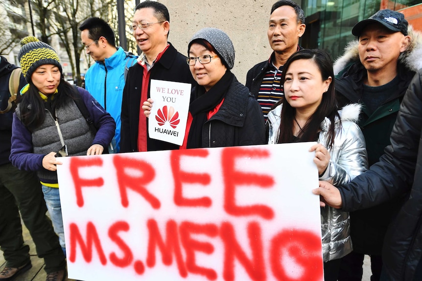 People hold a sign at a Vancouver, British Columbia courthouse prior to the bail hearing for Meng Wanzhou.