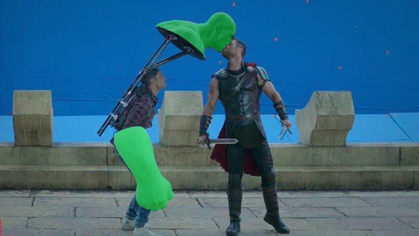 Thor played by Chris Hemsworth kissing a green screen Hulk