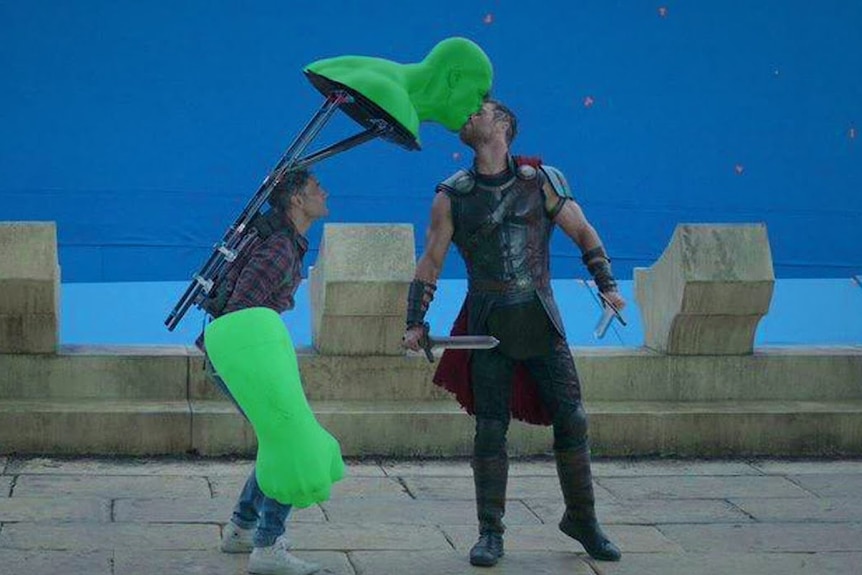 Thor played by Chris Hemsworth kissing a green screen Hulk