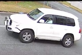 a CCTV still image of a white Landcruiser from the side angle
