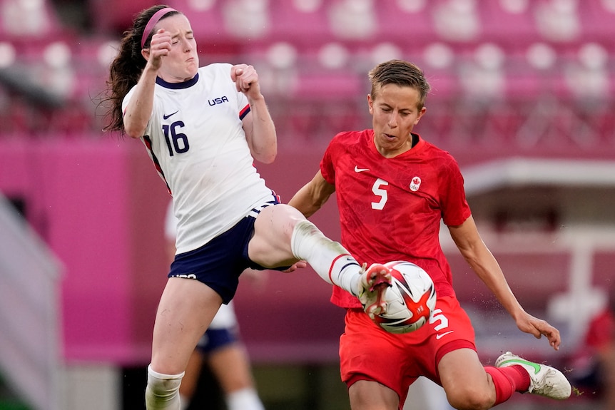 Two soccer players compete for the ball. 