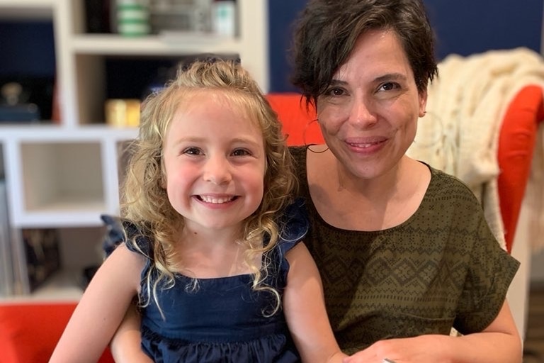 A mum and her daughter smile for a portrait