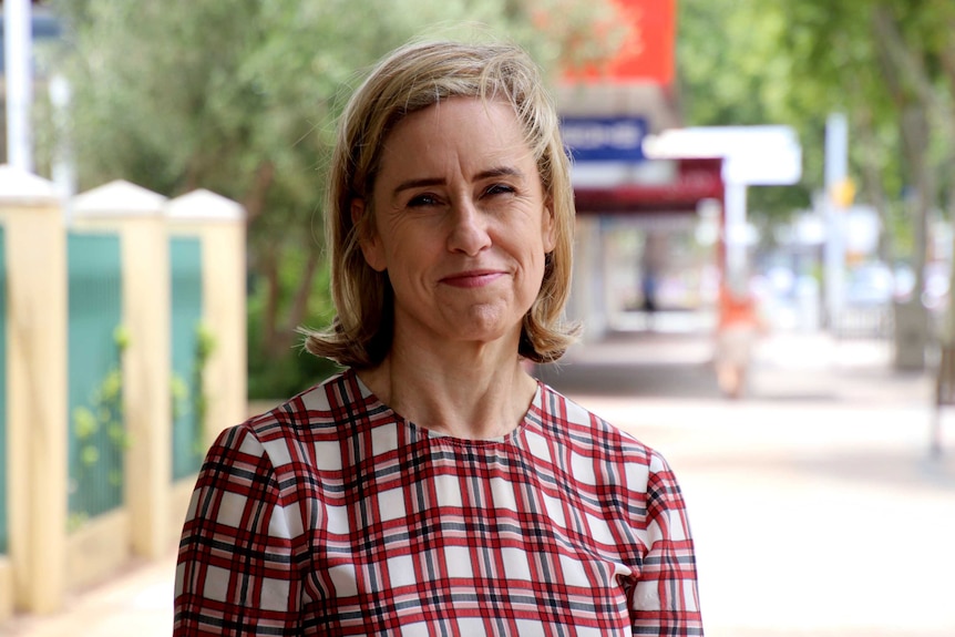 Ms McGurk stands on the street, smiling, looking into the camera.