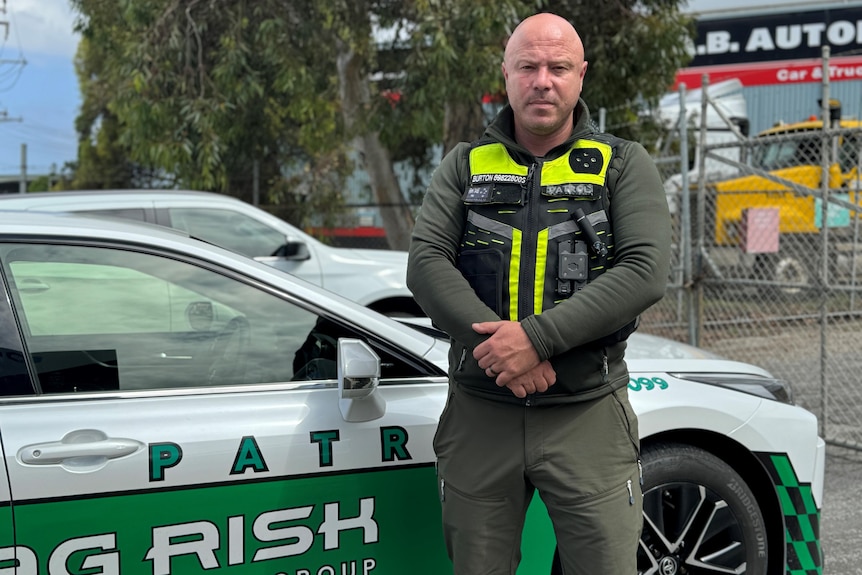 a man with a patrol car with green and white decals
