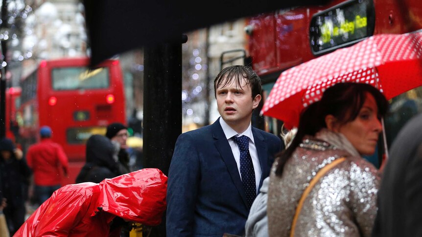 Pedestrians walk in wet and windy London weather