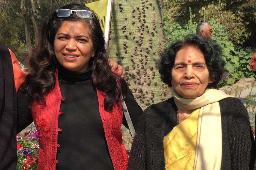 Jyoti and her mother pose for the camera at an outdoor setting. 