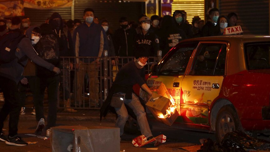 A protestor sets fire to a taxi during night time protests at Mongkok distrcit in Hong Kong